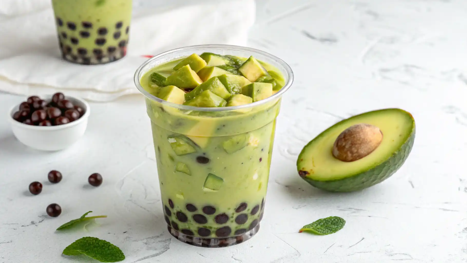 avocado boba drink with chewy tapioca pearls served in a tall glass