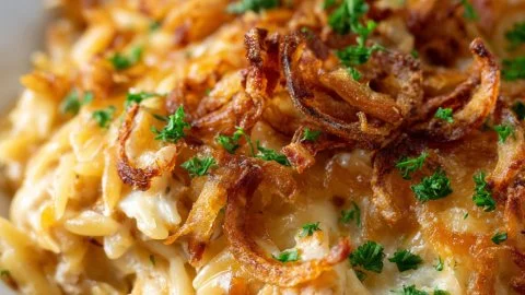 Delicious French onion chicken orzo casserole topped with melted cheese and herbs.