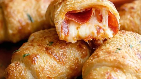 Pepperoni Pizza Crescent Rolls served on a plate with dipping sauce