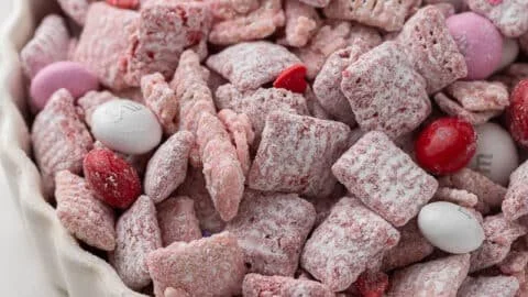 Valentine's Day themed Muddy Buddies snack with heart-shaped decorations.