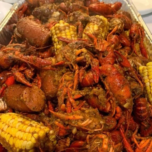 Seafood boil with garlic butter sauce served in a vibrant platter.